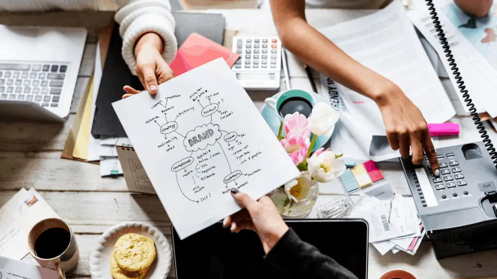 A branding strategy being handed across a work table