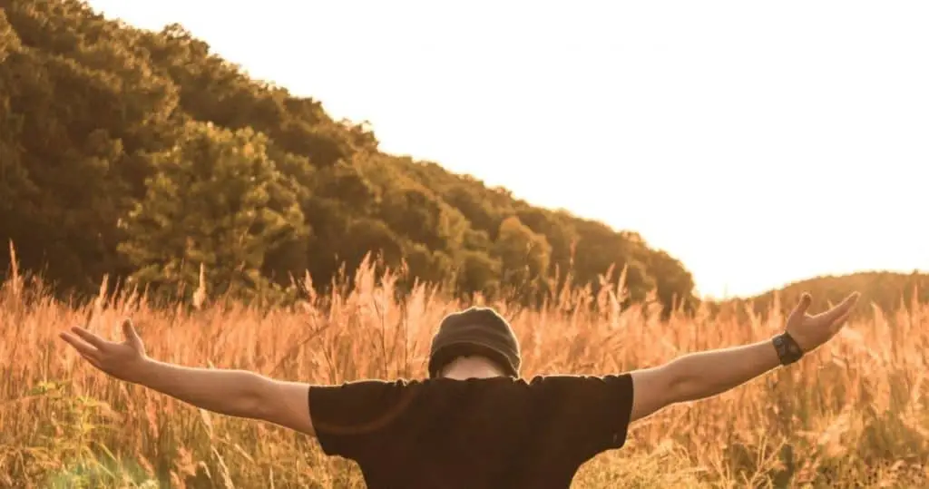 man bowing before God in an open field