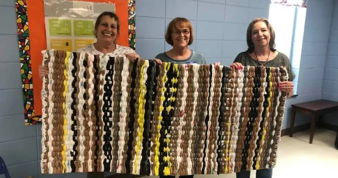 Ladies holding up a homeless mat they made as a ministry