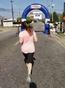 Miranda running across the finish line