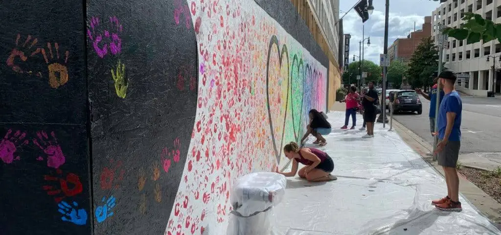 graffiti artist painting hearts on a wall