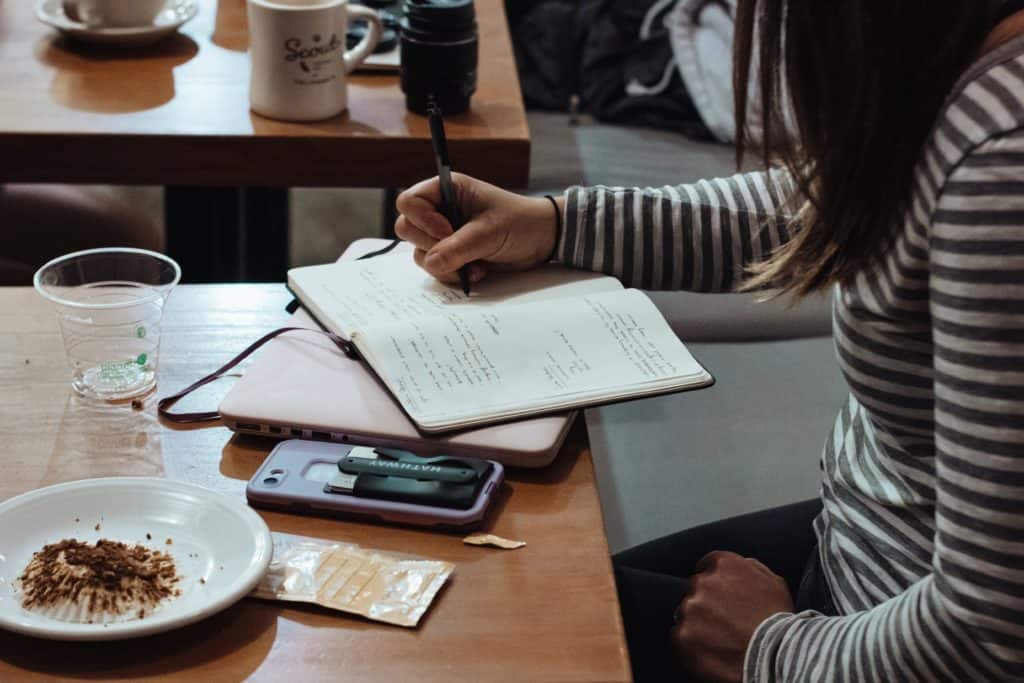 person writing in notebook