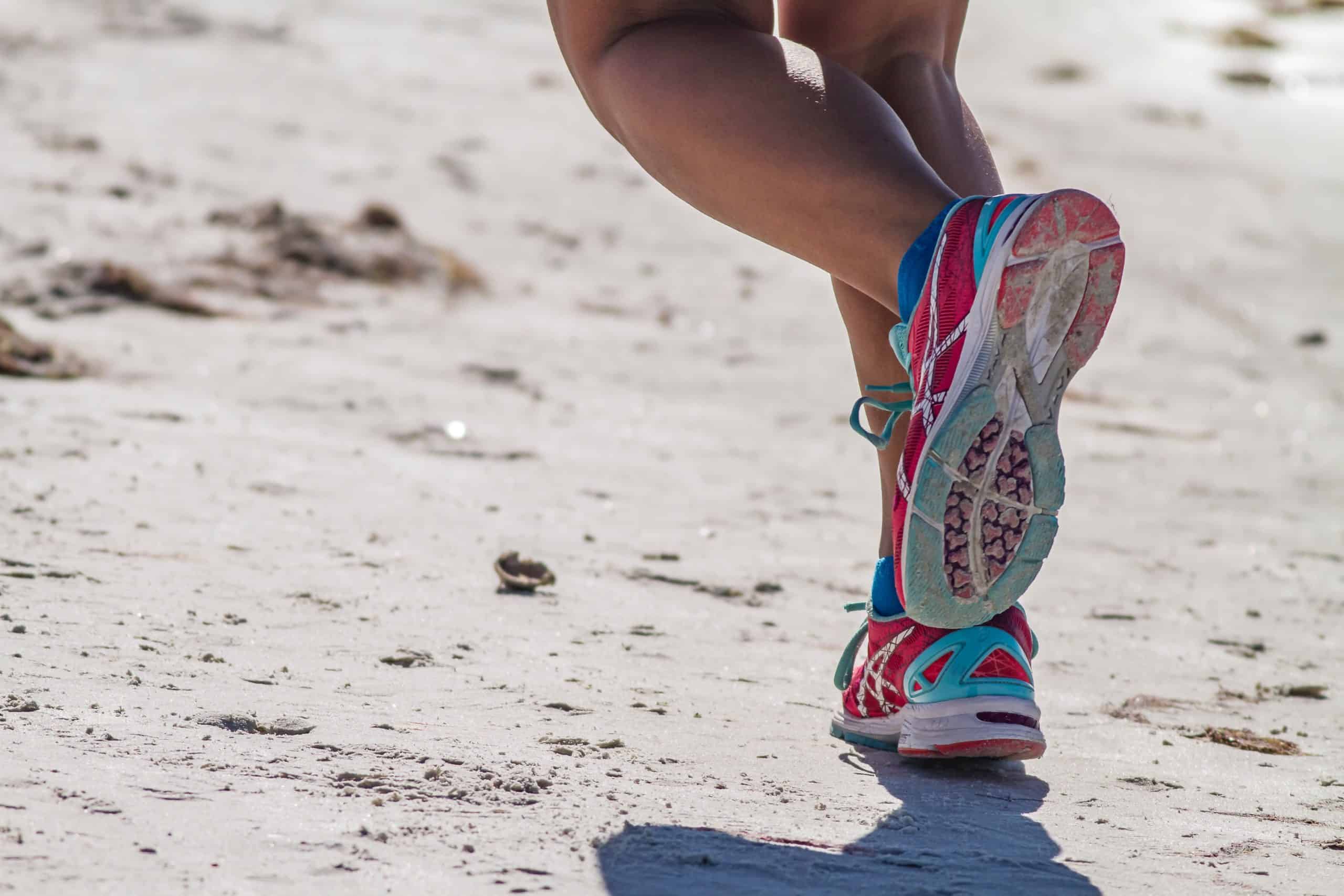 closeup of woman's running feet on beach