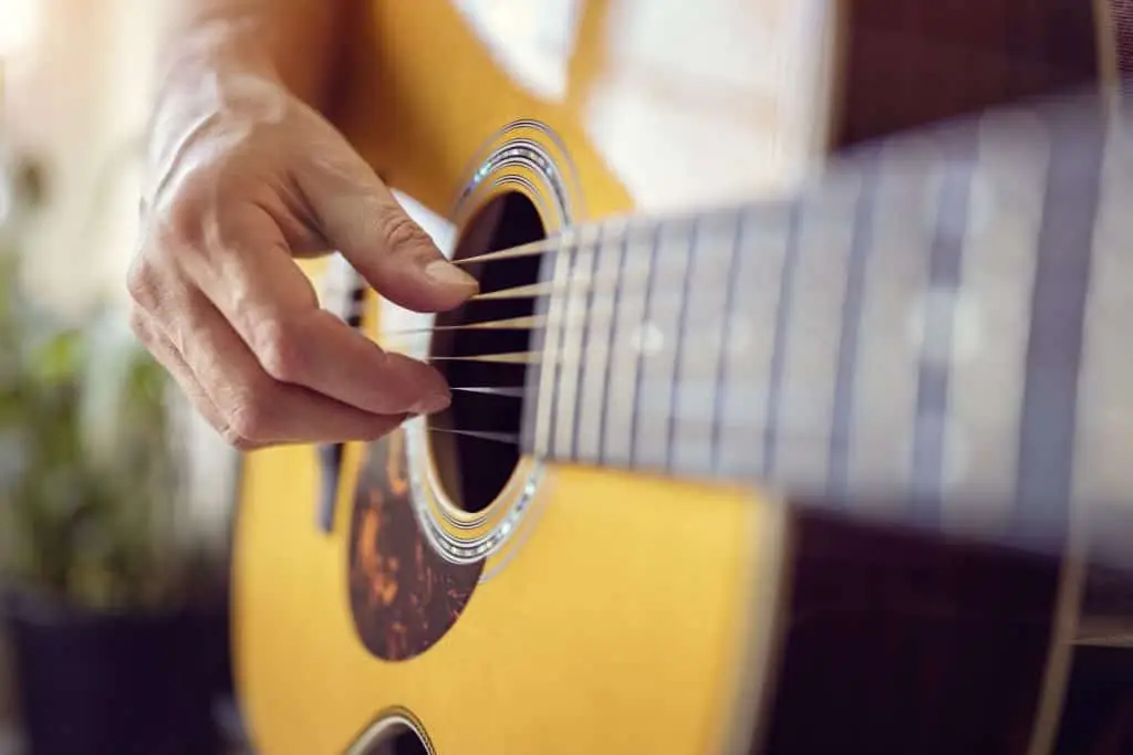 closeup of man playing country music on a guitar