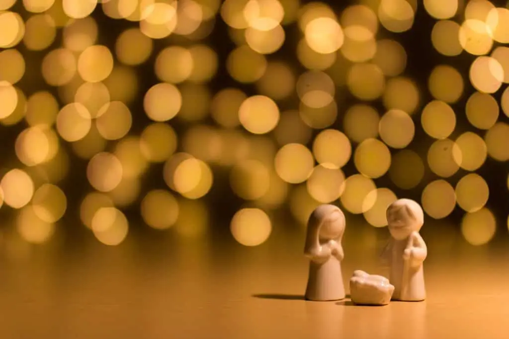 small nativity scene in front of glittery lights