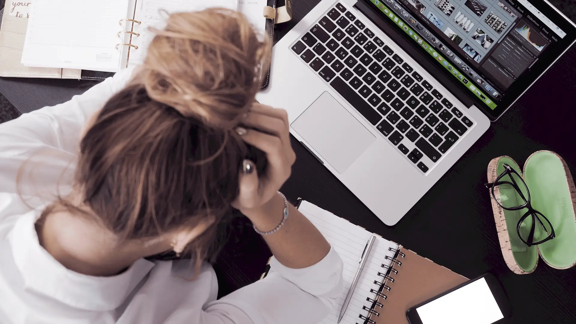 stressed out woman in front of laptop experiencing imposter syndrome