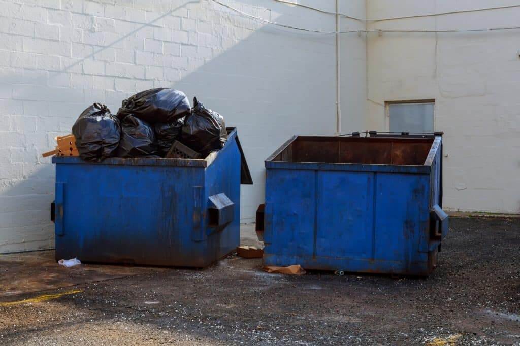 garbage container dumpster, recycle, waste and garbage bins near new office building. Backyard view